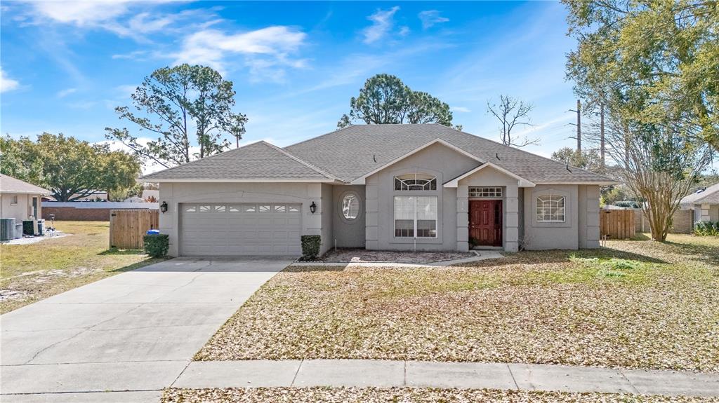 A single-story house with a gray stucco exterior, a two-car garage, and a brown roof — 134 ESTATES CIRCLE, LAKE MARY, FL