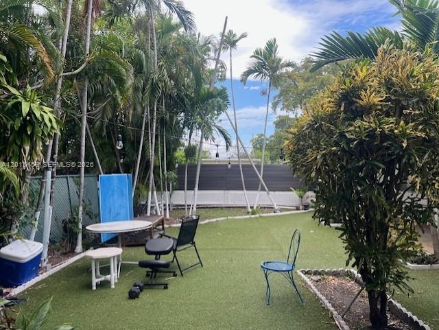 A backyard features artificial turf, palm trees, a small table, and several chairs — 732 Moffett # 4A, Hallandale Beach FL 33009, HALLANDALE BEACH, FL