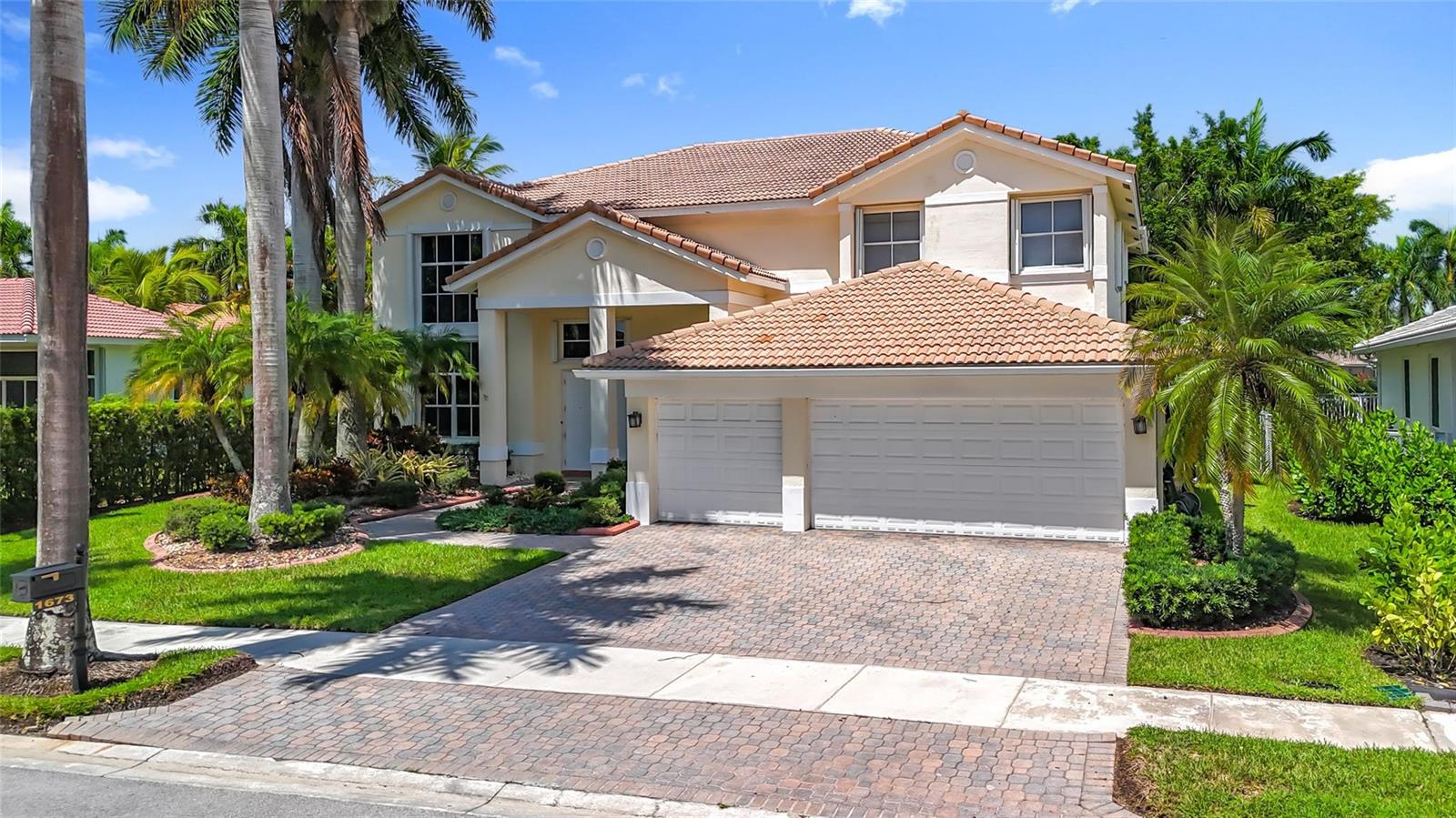 A two-story suburban house with a tiled roof, two-car garage, and a paved driveway — 1673 Victoria Pointe Circle, Weston FL 33327, WESTON, FL