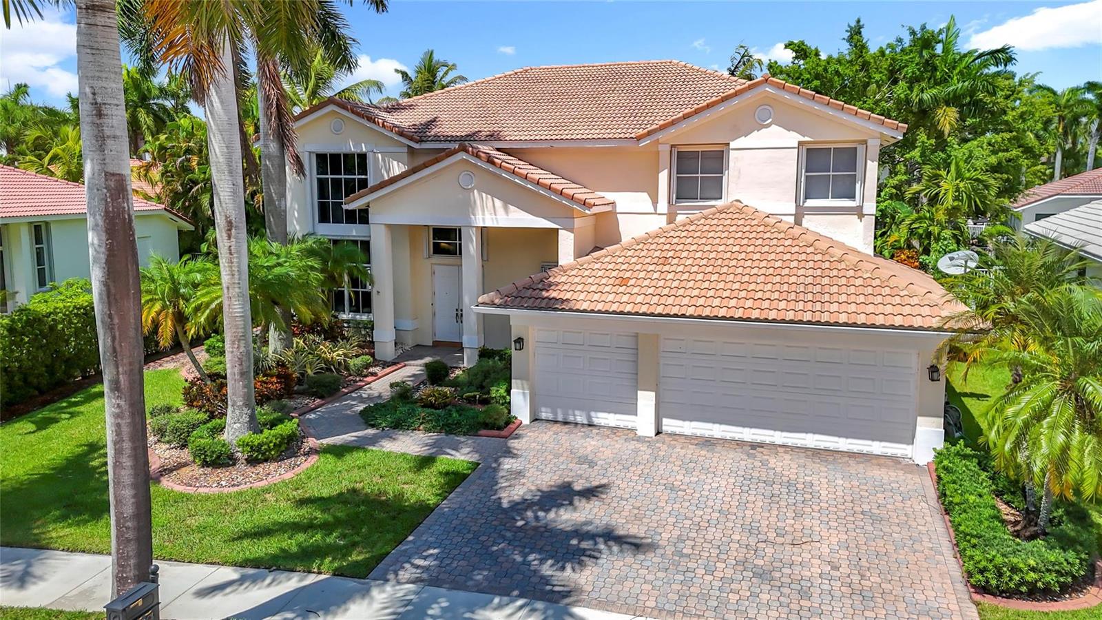 A two-story suburban house with a tiled roof, two-car garage, and a paved driveway — 1673 Victoria Pointe Circle, Weston FL 33327, WESTON, FL