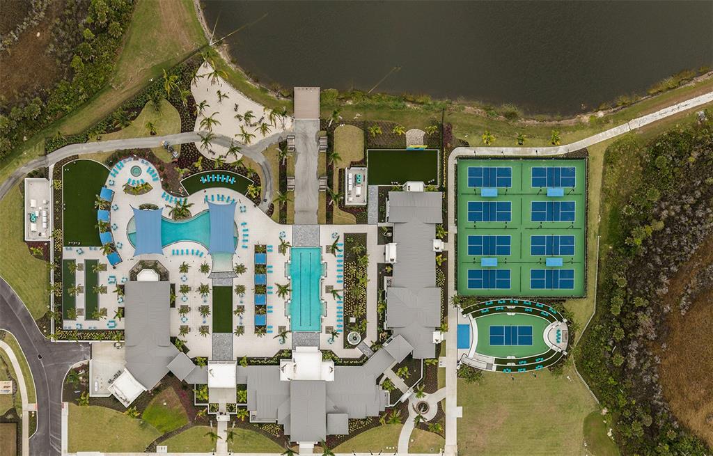 An aerial view shows a large clubhouse complex with swimming pools, tennis courts, and landscaping — 18312 CHROMATA DRIVE, VENICE, FL