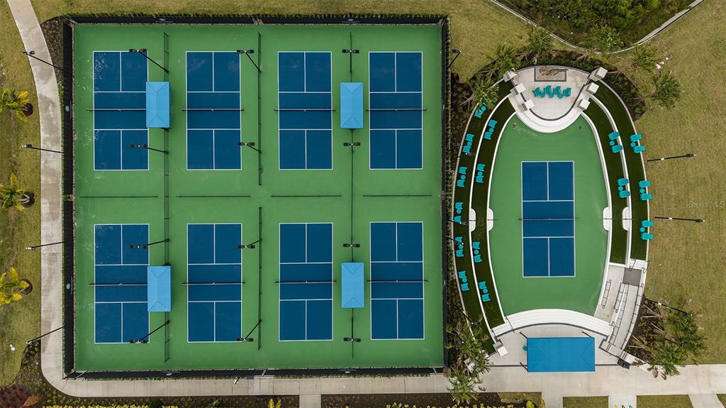 An aerial view shows eight pickleball courts and a stadium court with tiered seating — 18312 CHROMATA DRIVE, VENICE, FL