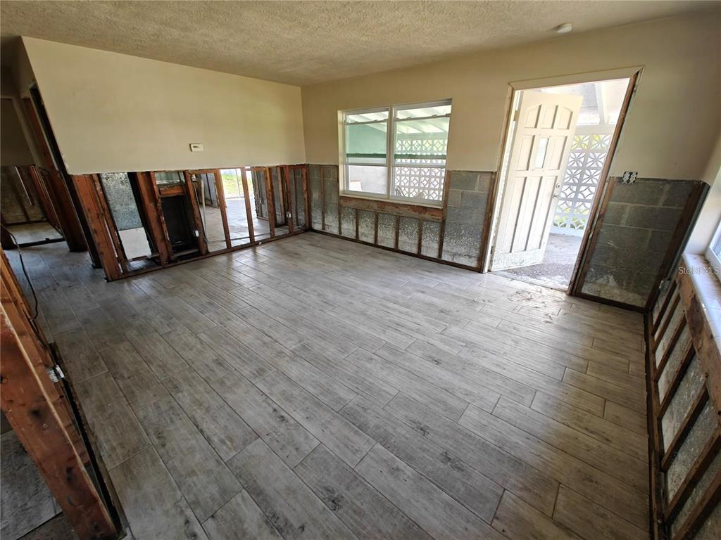 An unfinished room features exposed wall studs, concrete block walls, and wood-look tile flooring — 190 DANFORTH DRIVE, PUNTA GORDA, FL