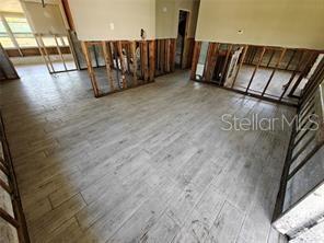 An interior room under renovation features exposed wall studs and light wood-look tile flooring — 190 DANFORTH DRIVE, PUNTA GORDA, FL