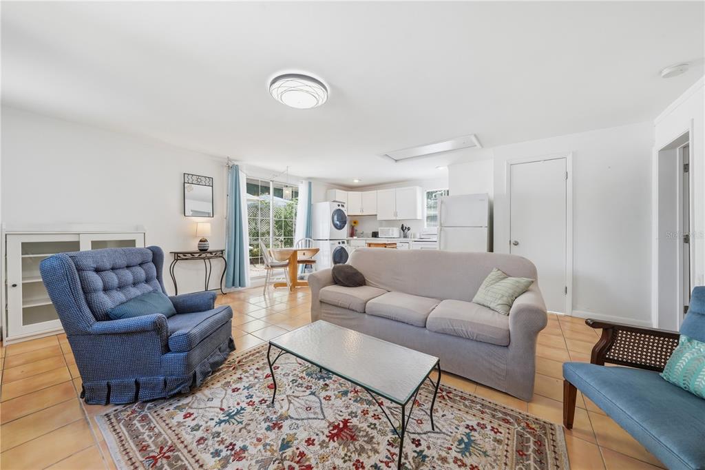 A living room with tile floors, a sofa, armchairs, and an open kitchen area — 206 E 9TH AVENUE, MOUNT DORA, FL