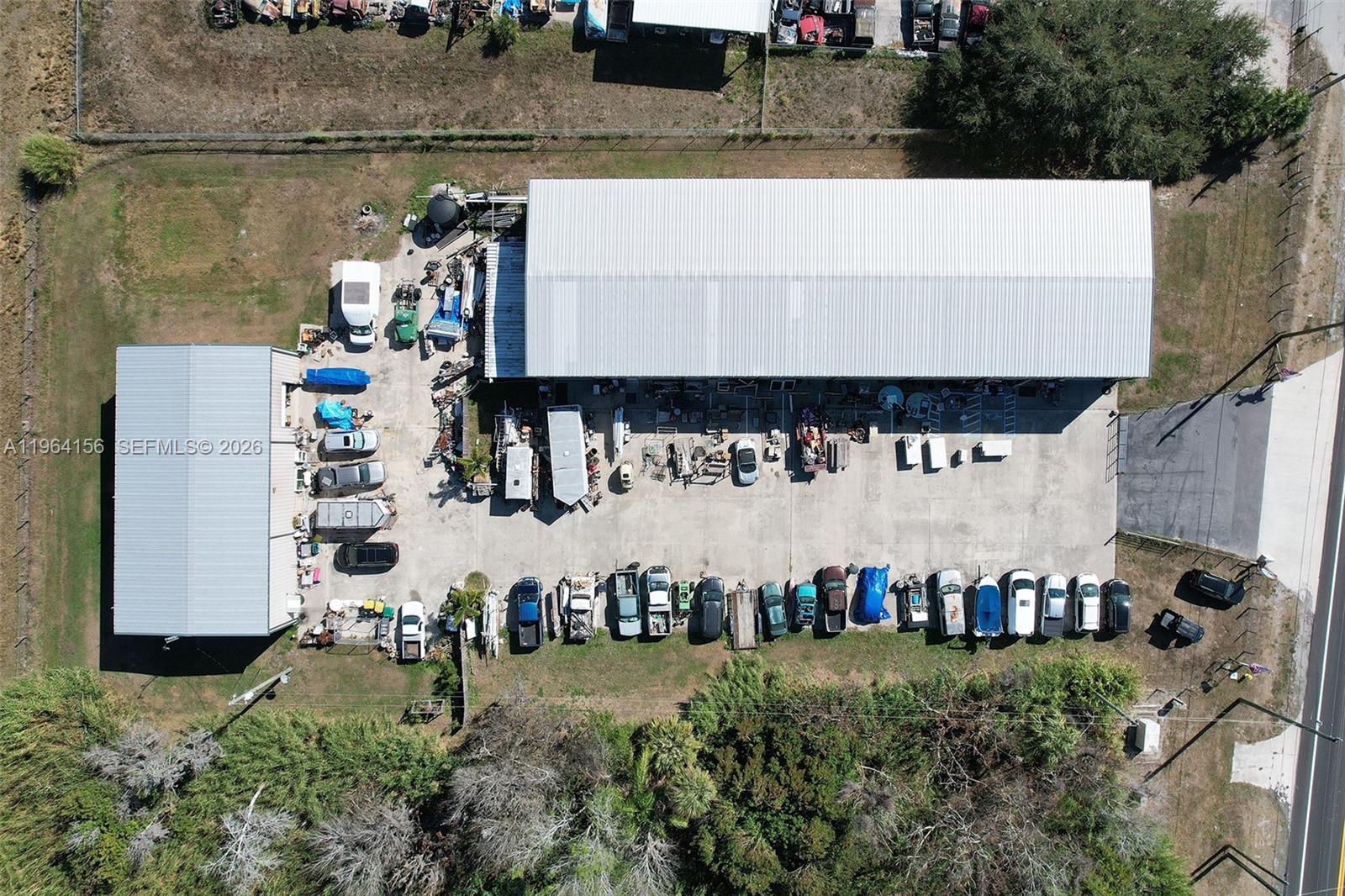 An aerial view shows two industrial buildings surrounded by a parking lot filled with vehicles — 5271 US HWY 441 SE, Okeechobee FL 34974, OKEECHOBEE, FL