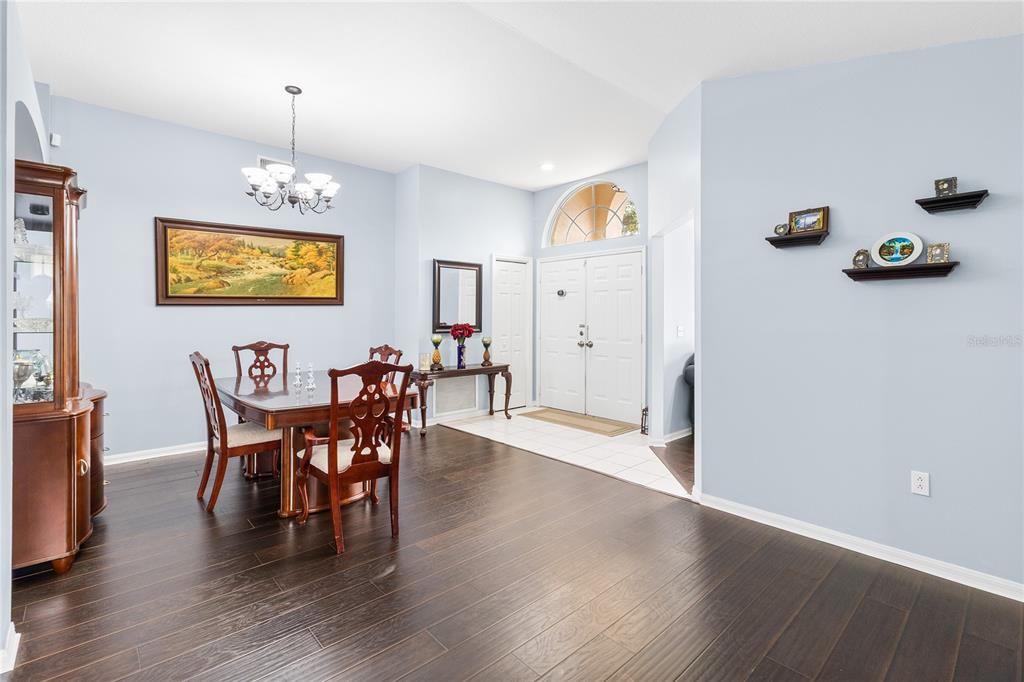 A dining room with dark wood floors, a chandelier, and a double-door entryway — 1622 HULETT DRIVE, BRANDON, FL