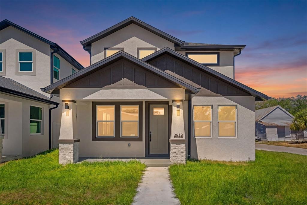 A two-story house with a gray stucco exterior, dark trim, and a covered front porch — 2912 N 21ST STREET, TAMPA, FL