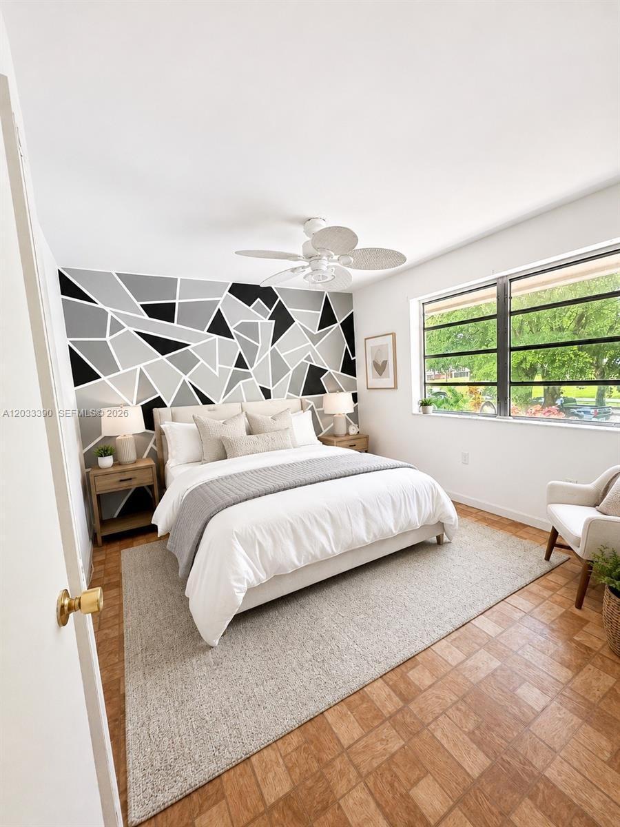 A bedroom features a geometric accent wall, a white bed, and parquet wood flooring — 8480 SW 154th Cir Ct # 924, Miami FL 33193, MIAMI, FL