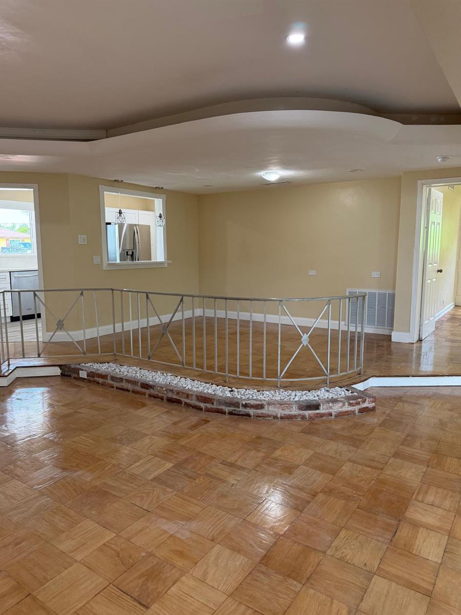 A sunken living area features parquet wood flooring, a brick planter, and a metal railing — 1405 6th Street, West Palm Beach FL 33401, WEST PALM BEACH, FL