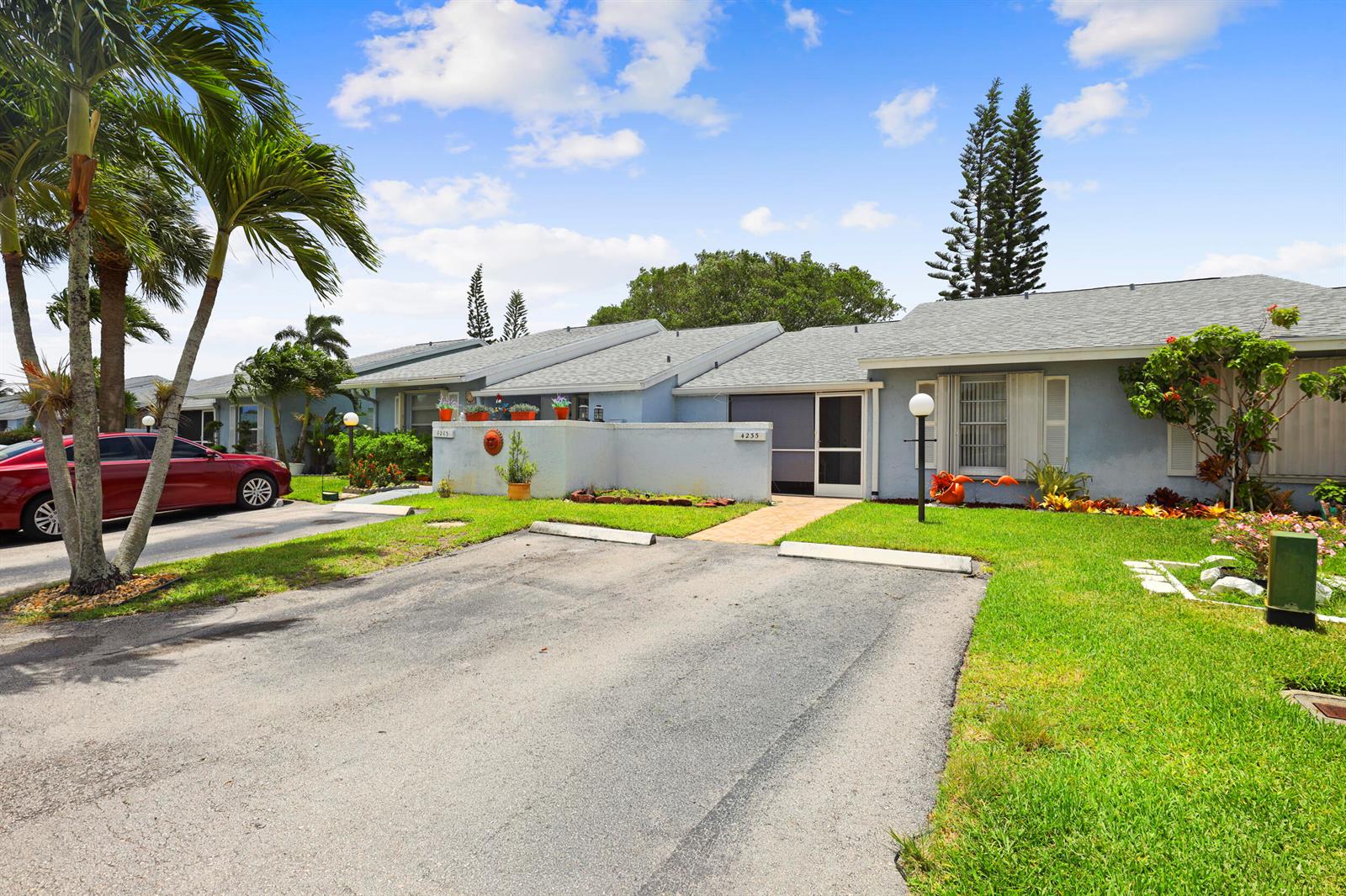 A single-story residential building with a paved driveway and palm trees under a blue sky — 4235 Lucerne Villas Lane, FL 33467, FL