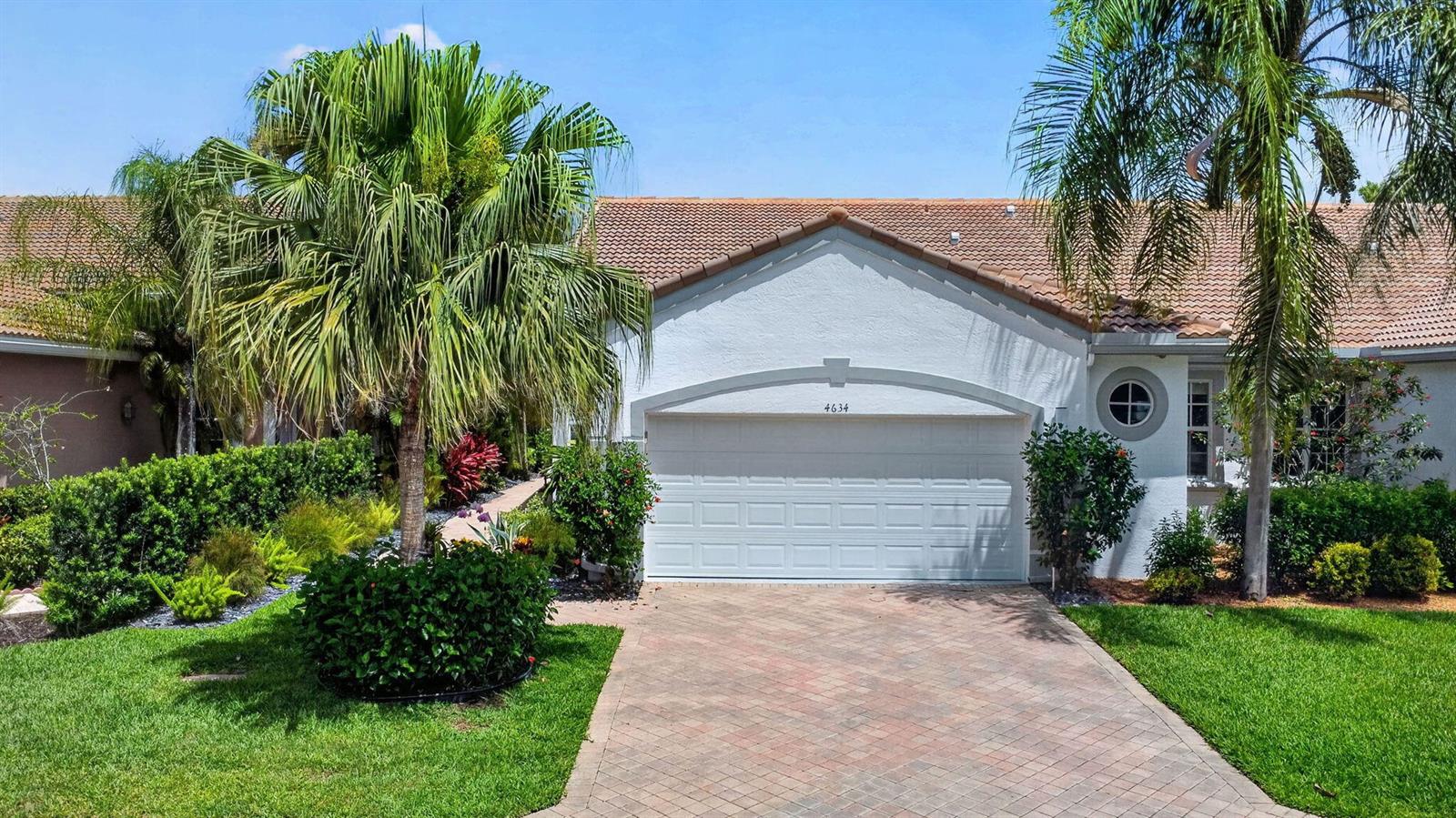 A single-story house with a white stucco exterior, a tiled roof, and a paved driveway — 4634 Carlton Golf Drive, Lake Worth FL 33449, LAKE WORTH, FL