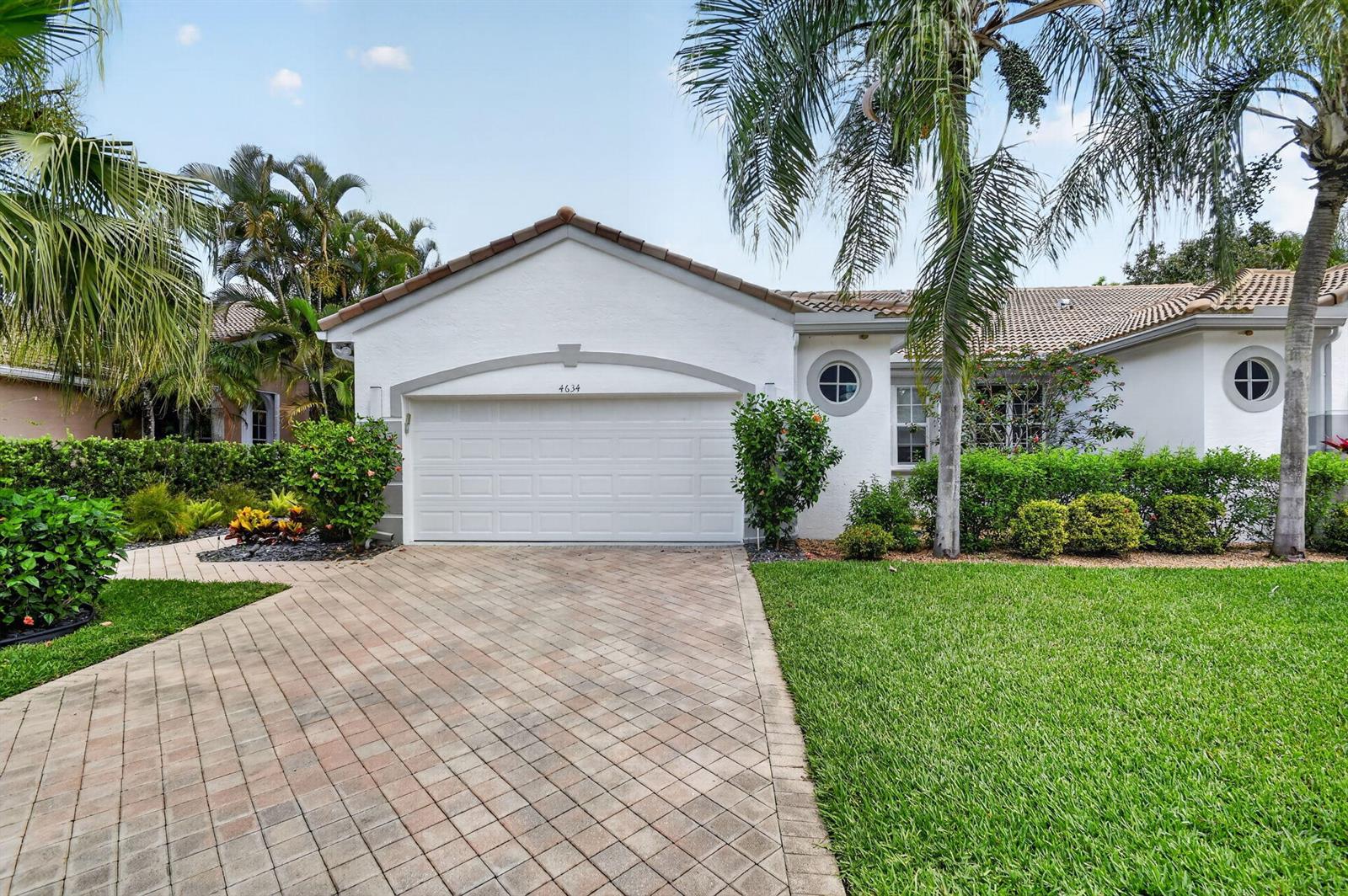 A white house with a paved driveway, palm trees, and a two-car garage — 4634 Carlton Golf Drive, Lake Worth FL 33449, LAKE WORTH, FL