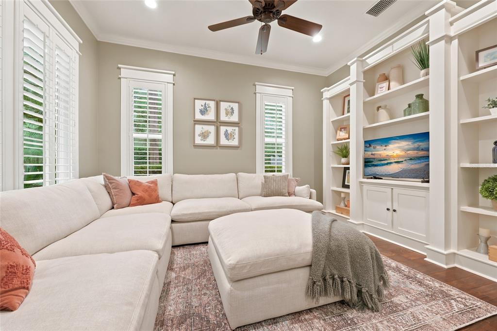 A living room features a large sectional sofa, an ottoman, and built-in white shelving units — 774 SW 134TH WAY, NEWBERRY, FL