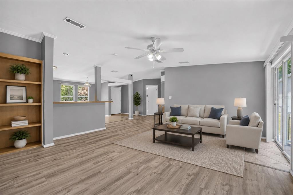 A living room features gray walls, wood-look flooring, a beige sofa, and a built-in bookshelf — 357 WALTER PLACE, FRUITLAND PARK, FL