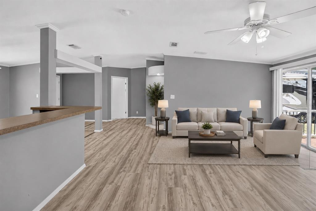A living room features gray walls, light wood-look flooring, a beige sofa, and a ceiling fan — 357 WALTER PLACE, FRUITLAND PARK, FL