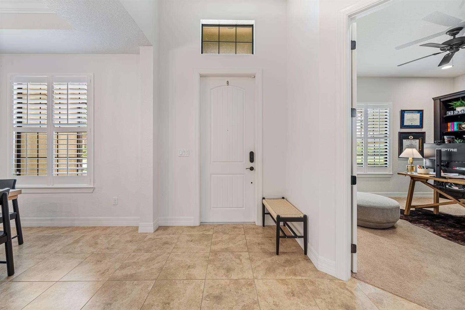 An entryway features a white front door, a small bench, and tile flooring — 4591 Siena Circle, Wellington FL 33414, WELLINGTON, FL