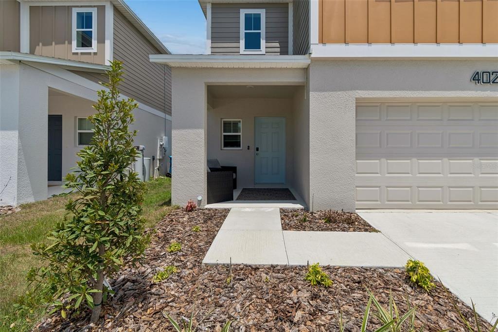 The exterior of a two-story house features a light blue front door and garage — 4023 GARDENIA AVE, HAINES CITY, FL