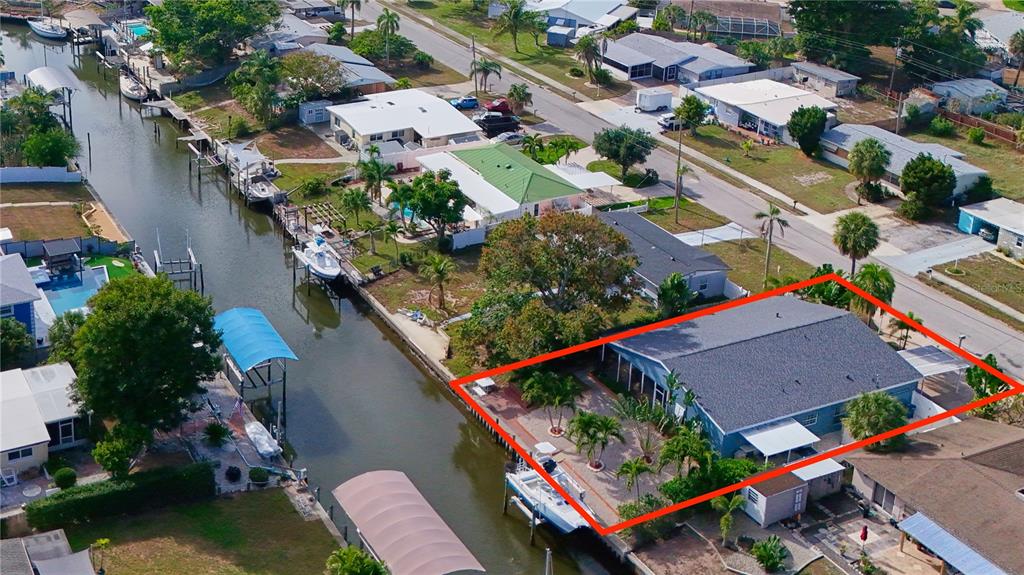 An aerial view of a waterfront house with a large backyard and a private boat dock — 6811 GEORGIA AVENUE, BRADENTON, FL