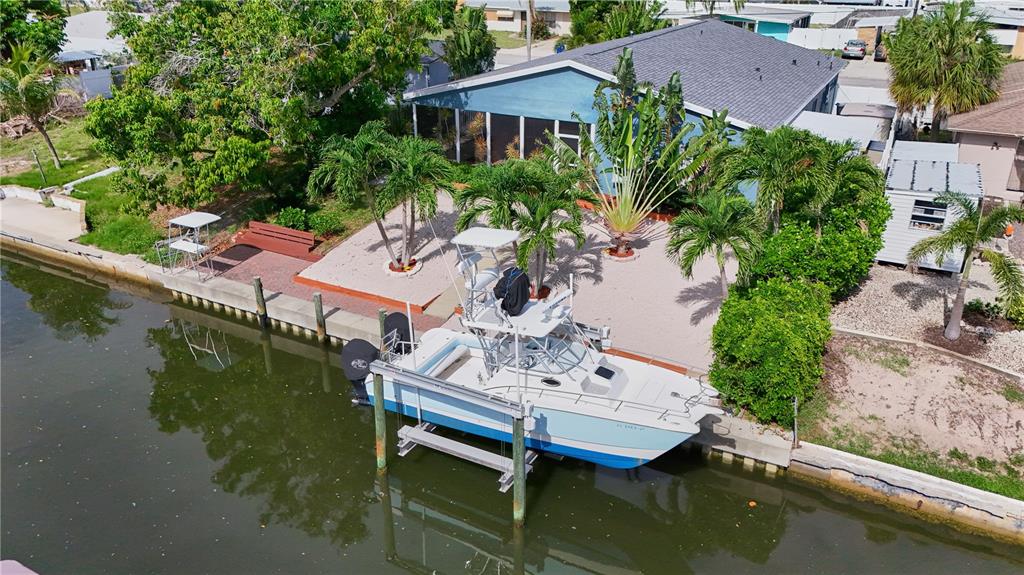 An aerial view of a blue house with a boat on a lift in a canal — 6811 GEORGIA AVENUE, BRADENTON, FL