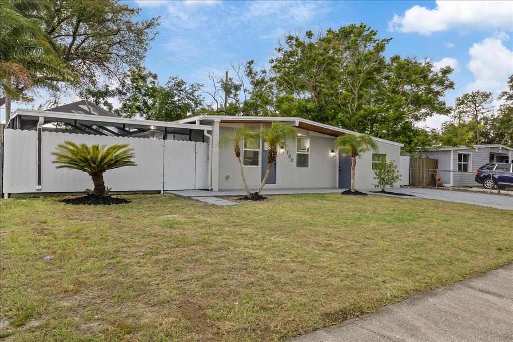 A single-story house with a white fence, palm trees, and a gray driveway — 1130 DOGWOOD AVENUE, TAMPA, FL