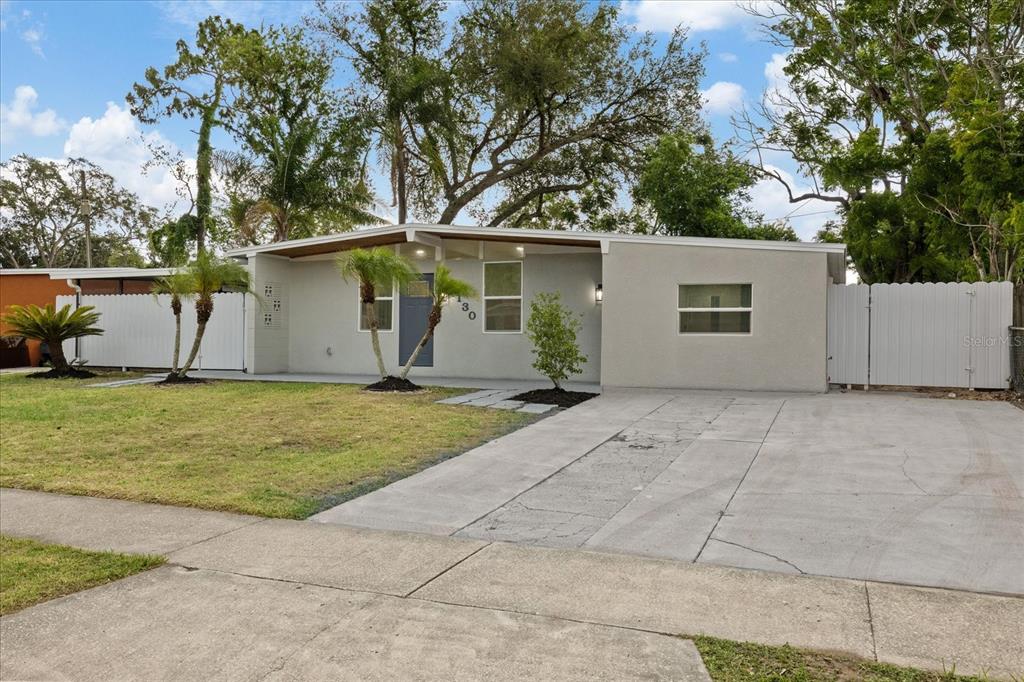 A single-story house with a gray exterior, a concrete driveway, and a white privacy fence — 1130 DOGWOOD AVENUE, TAMPA, FL