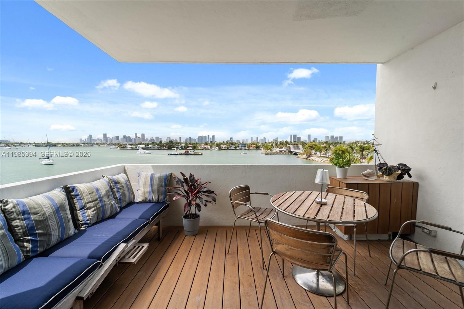 A balcony with wood decking, outdoor furniture, and a panoramic view of a city skyline — 3 Island Ave # 04I, Miami Beach FL 33139, MIAMI BEACH, FL