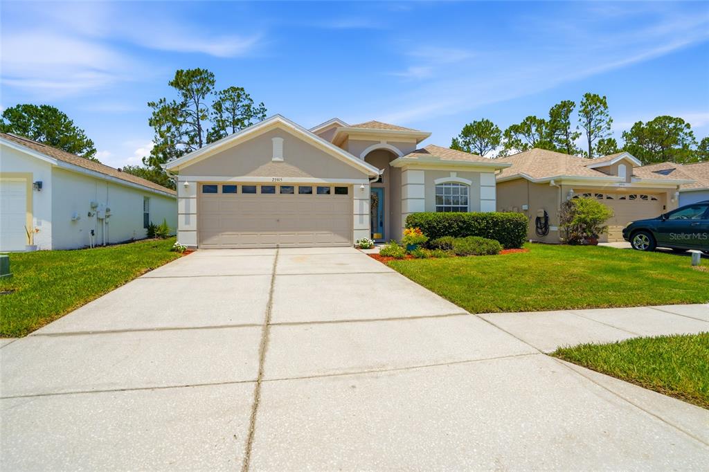 An entryway features light-colored tile flooring, gray walls, a front door with glass, and cutouts — 23915 CORAL RIDGE LANE, LAND O LAKES, FL