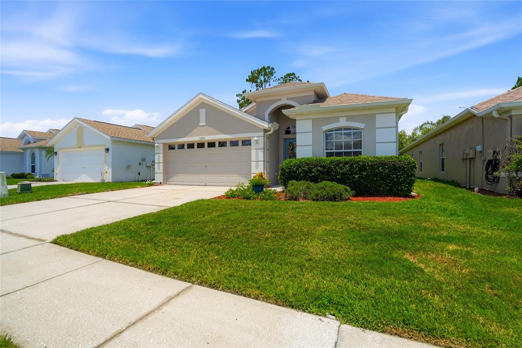 A home office with gray walls, a dark desk, two leather armchairs, and a large window — 23915 CORAL RIDGE LANE, LAND O LAKES, FL