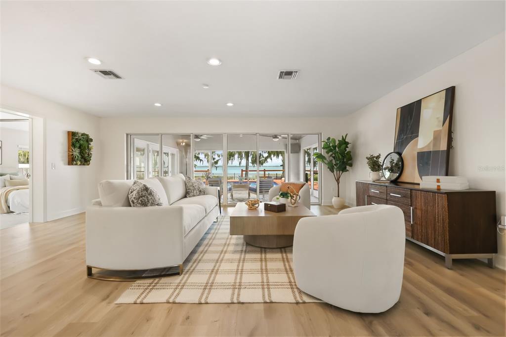 A living room features a white sofa, two armchairs, a wooden coffee table, and sliding doors — 32749 LAKE EUSTIS DRIVE, TAVARES, FL