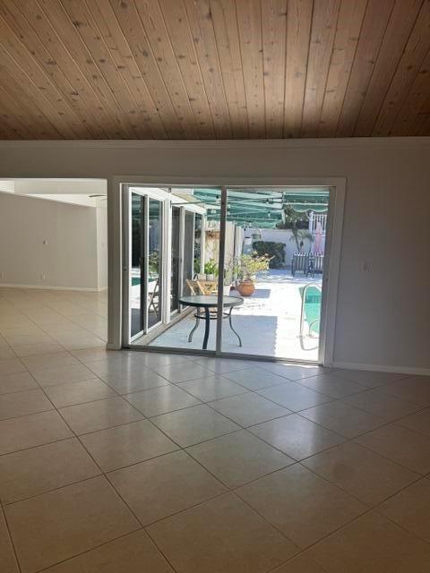 A room with light-colored tile flooring and a wood-paneled ceiling overlooks a patio and pool — 112 E Coral Fish Lane, Jupiter FL 33477, JUPITER, FL