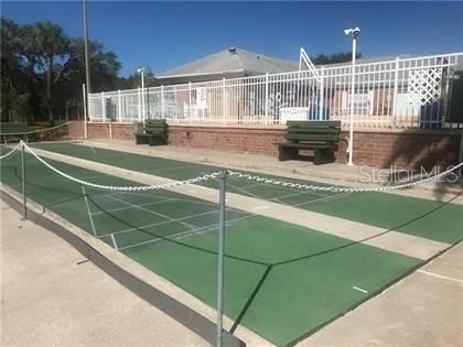 A shuffleboard court sits in front of a fenced pool area with outdoor benches — 3440 41ST AVE SOUTH UNIT 187, ST PETERSBURG, FL