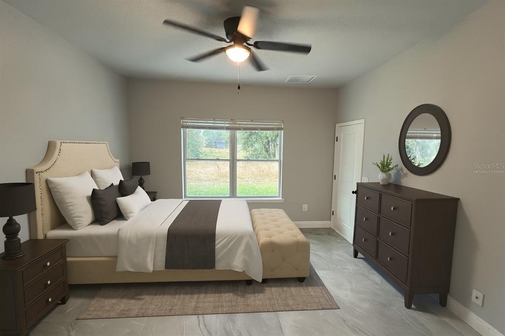 A bedroom features a bed, a dresser with a mirror, and tile flooring — 373 AMBERJACK, POINCIANA, FL