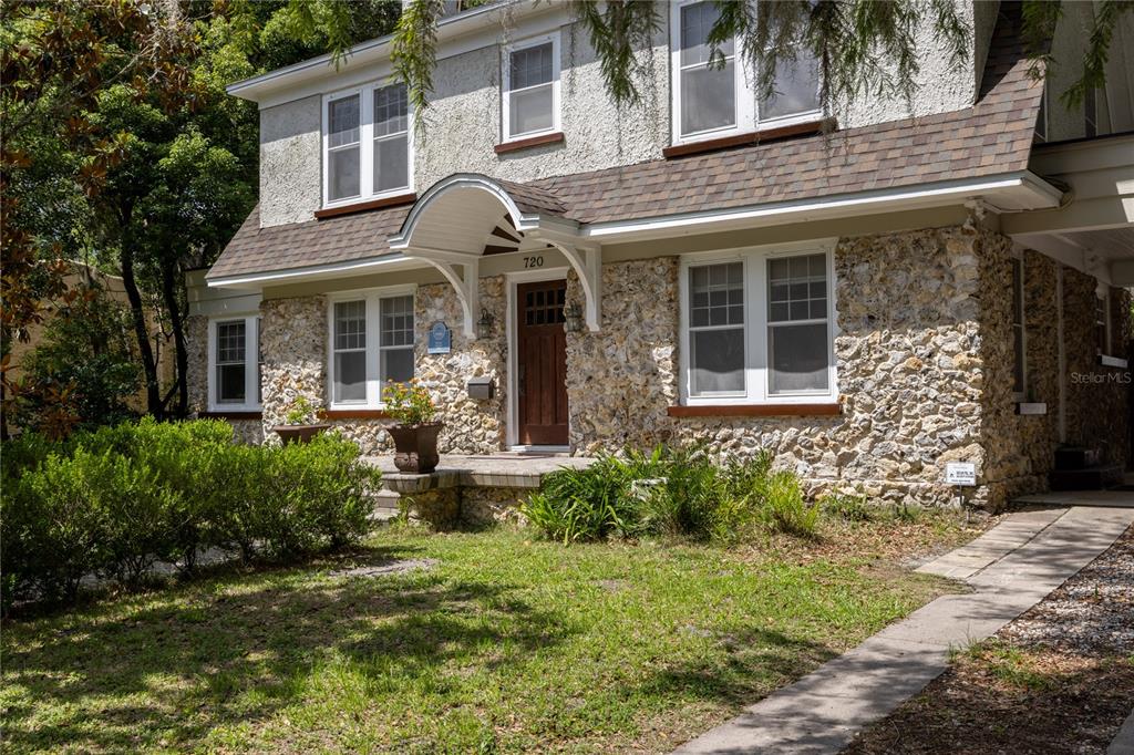 A two-story house features a stone facade, a covered entryway, and a front lawn — 720 NE BOULEVARD, GAINESVILLE, FL