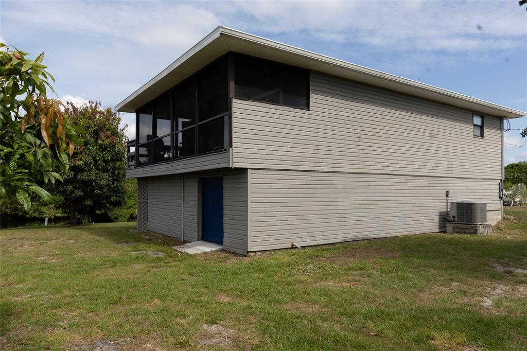 The exterior of a two-story house features gray horizontal siding and a screened-in upper porch — 29103 ORVA DRIVE, PUNTA GORDA, FL