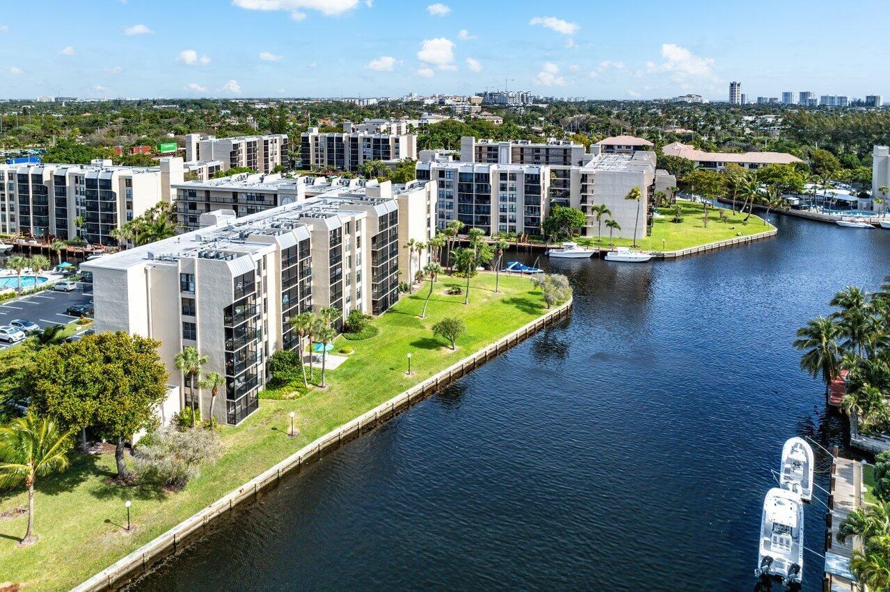 An aerial view of multi-story apartment buildings situated along a canal with docked boats — 13 Royal Palm Way # 602, Boca Raton FL 33432, BOCA RATON, FL