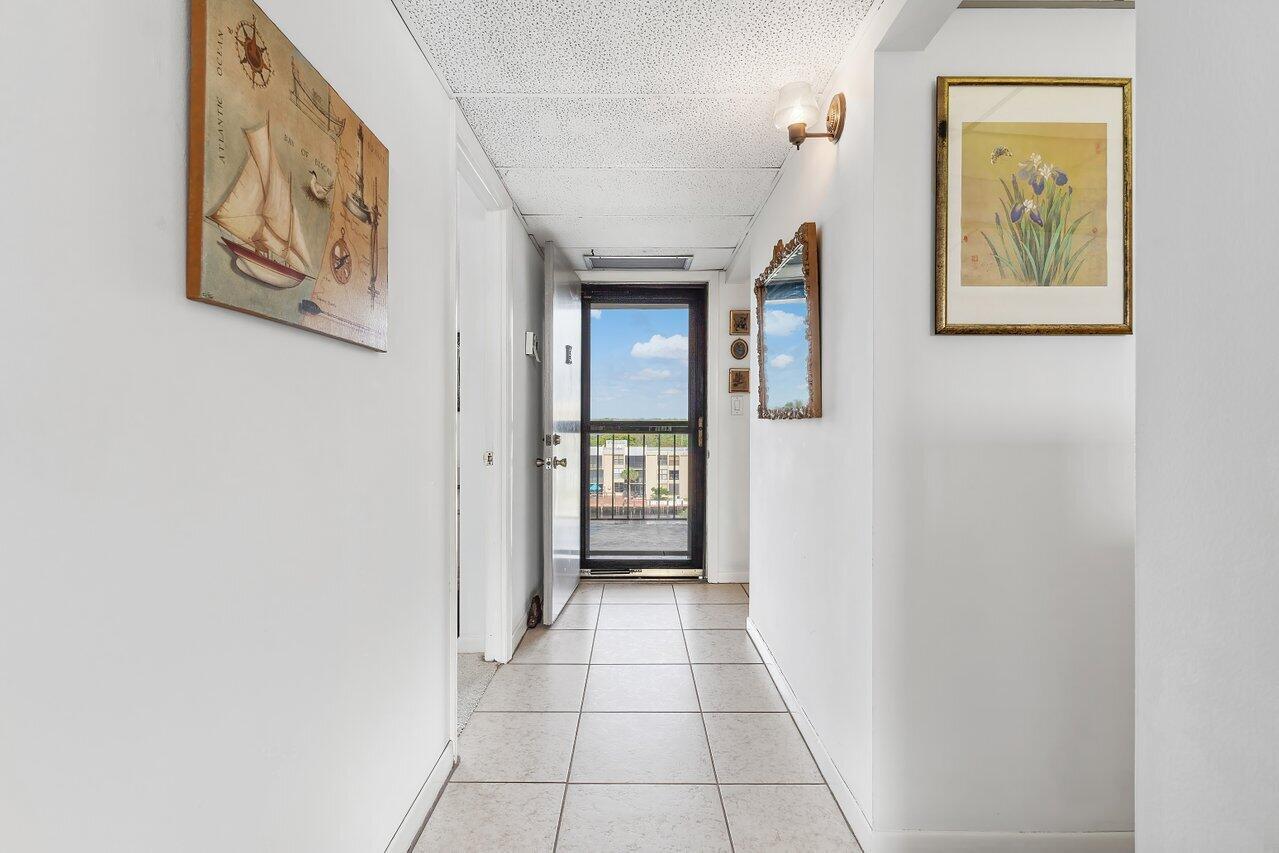 A tiled hallway leads to a glass door opening onto an outdoor balcony — 13 Royal Palm Way # 602, Boca Raton FL 33432, BOCA RATON, FL