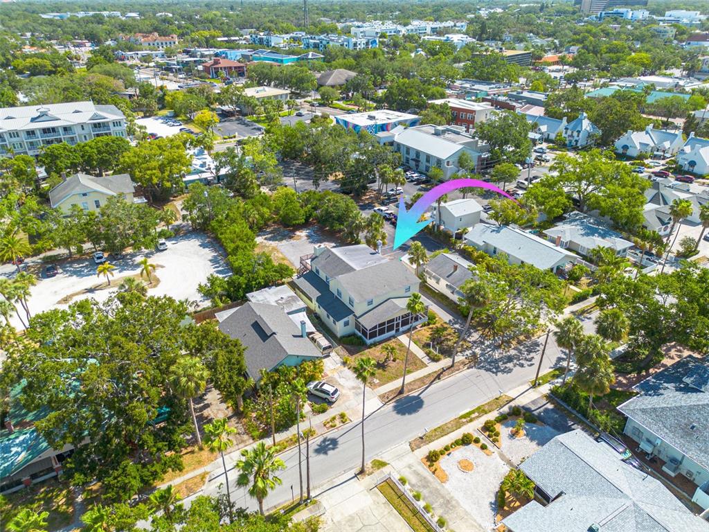 An aerial view shows a multi-story house with a screened porch and surrounding trees — 220 SCOTLAND STREET, DUNEDIN, FL