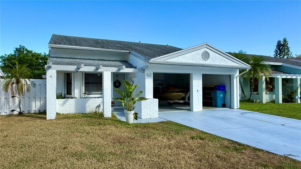 A white single-story house features a two-car garage, a front porch, and a paved driveway — 22 PAXFORD LANE, BOYNTON BEACH, FL