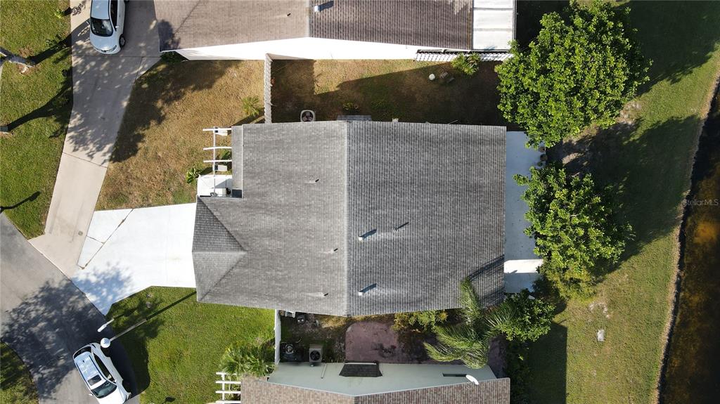 An aerial view shows a house with a gray shingled roof and surrounding yard — 22 PAXFORD LANE, BOYNTON BEACH, FL