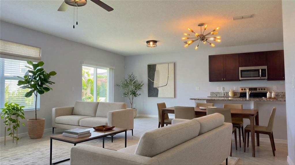 An open-concept living and dining area features light walls, neutral furniture, and dark wood cabinets — 5110 FIDDLEWOOD WAY, ST CLOUD, FL