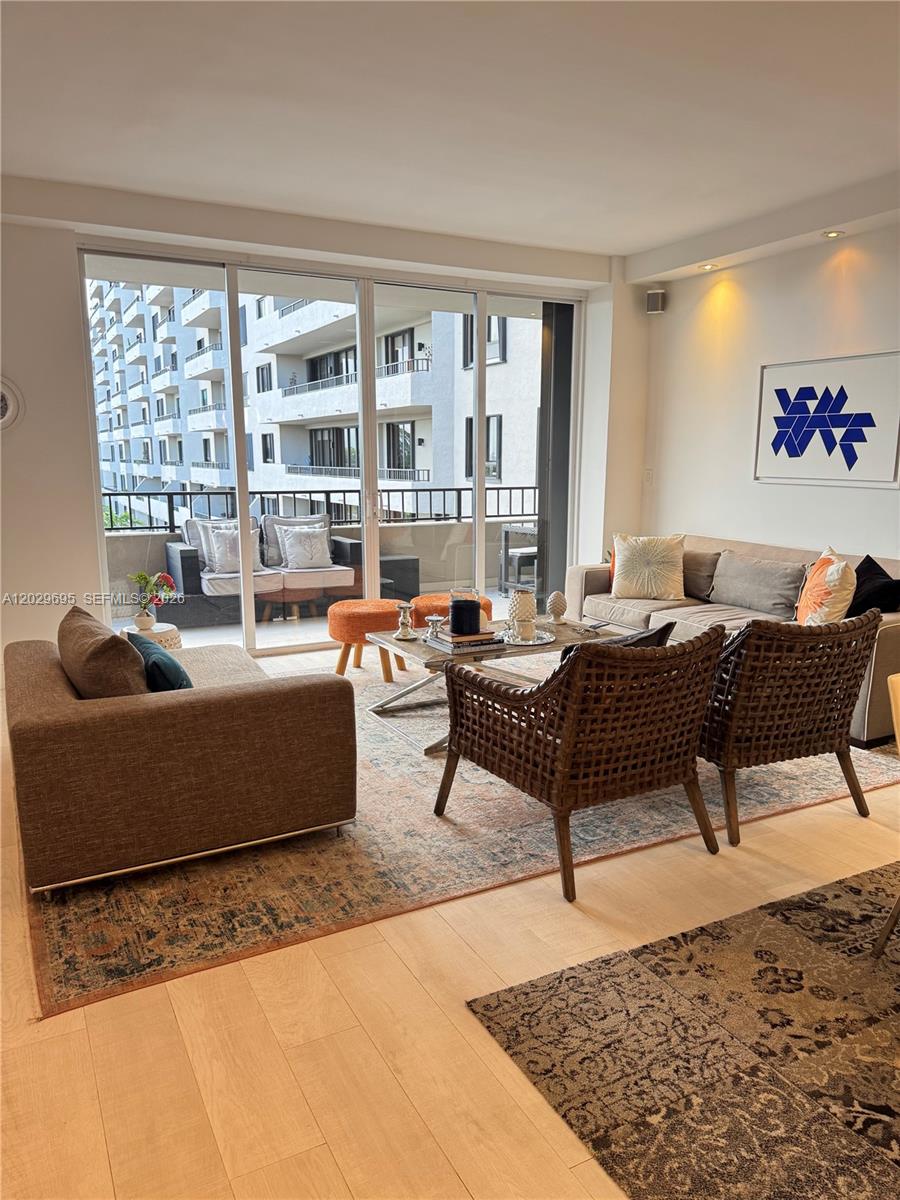 A living room features a sofa, two woven chairs, a coffee table, and a balcony — 151 Crandon Blvd # 405, Key Biscayne FL 33149, KEY BISCAYNE, FL