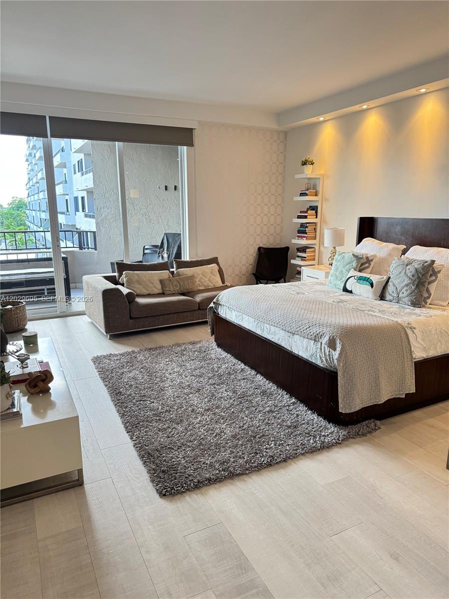 A bedroom features a large bed, a sofa, a bookshelf, and a balcony with outdoor seating — 151 Crandon Blvd # 405, Key Biscayne FL 33149, KEY BISCAYNE, FL