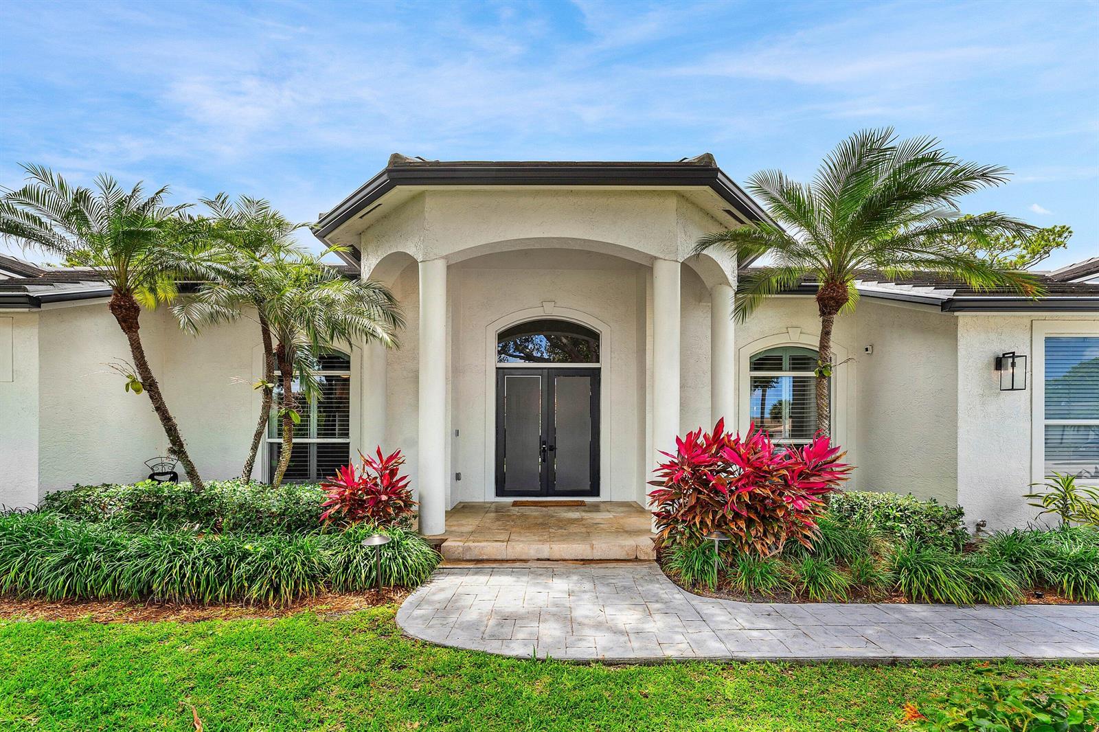 The front exterior of a white house features a covered entryway with two large columns — 1505 Addison Avenue, Boca Raton FL 33486, BOCA RATON, FL