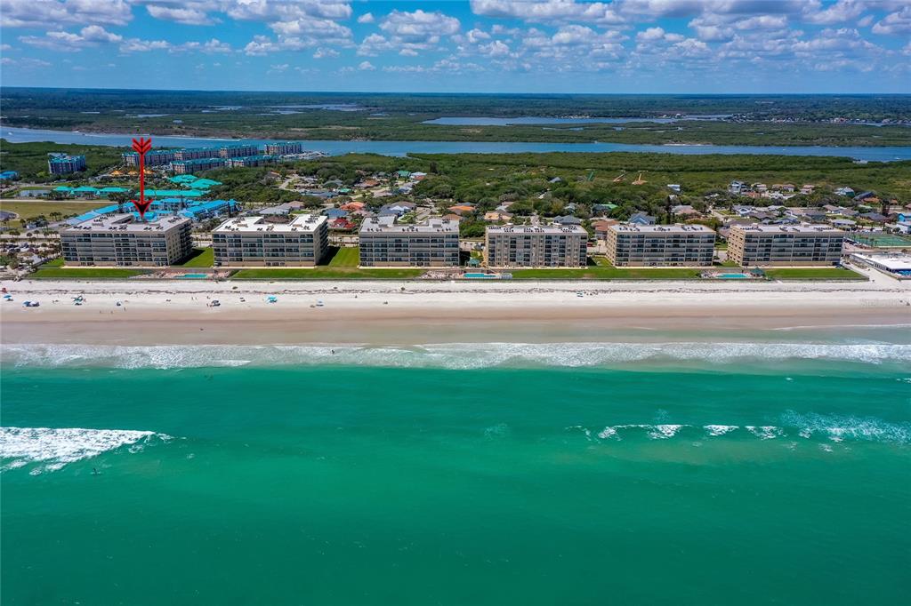An aerial view of several beachfront condominium buildings along a sandy coastline — 4575 S ATLANTIC AVENUE UNIT 6101, PORT ORANGE, FL