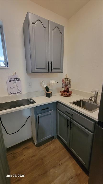 A small kitchen features gray cabinets, a stainless steel sink, and a black cooktop — 345 N THOMPSON ROAD UNIT B, APOPKA, FL