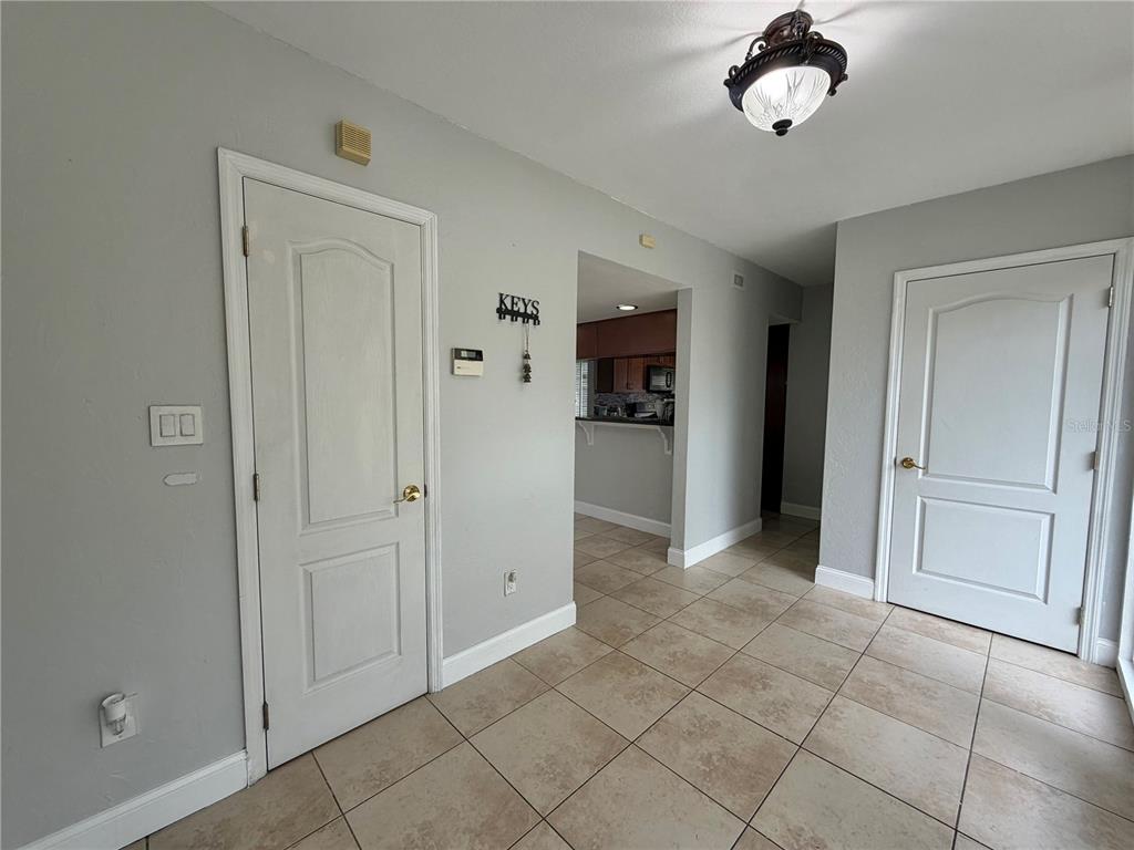 A tiled entryway features two white doors, a light fixture, and a view into a kitchen — 6 ROBYN LANE, HAINES CITY, FL