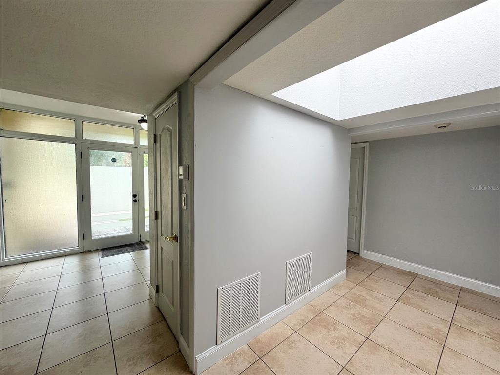 An entryway with tiled floors, a skylight, and a white door leading to the exterior — 6 ROBYN LANE, HAINES CITY, FL