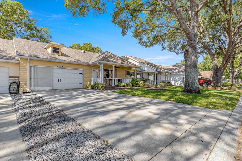 A yellow single-story house with a white garage door and a front porch — 9256 SW 82ND TERRACE UNIT E, OCALA, FL