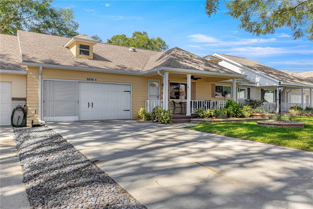 A yellow house with a garage, a front porch, and a concrete driveway — 9256 SW 82ND TERRACE UNIT E, OCALA, FL